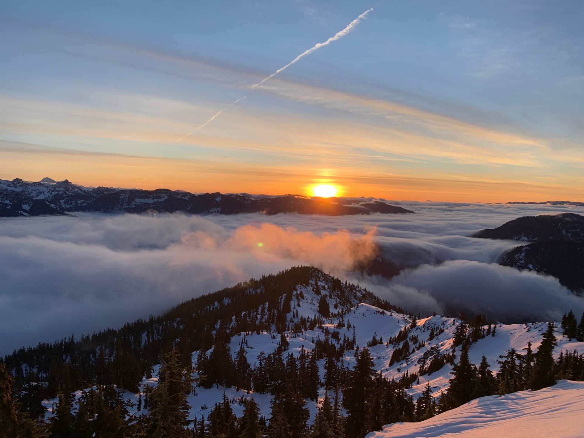 Sunset above snow-covered ridges and clouds